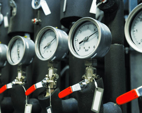 A row of pressure gauges displayed on a wall in a hydraulic distributor room, indicating various pressure levels.